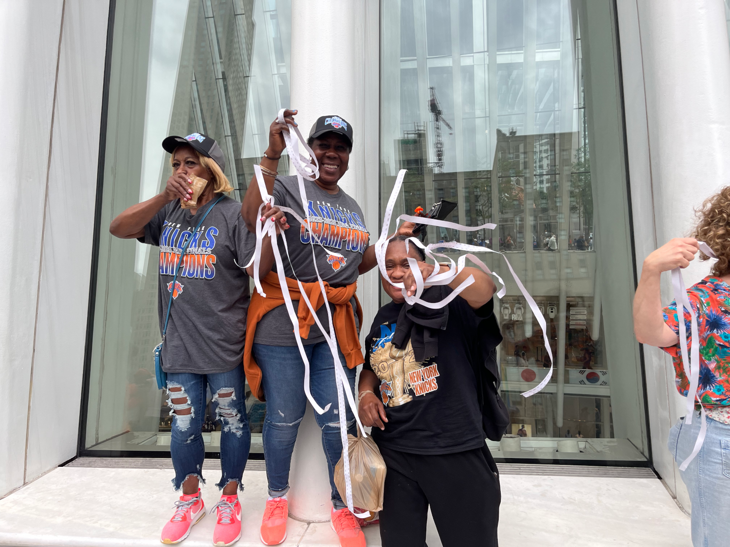 three women holding ticker-tape